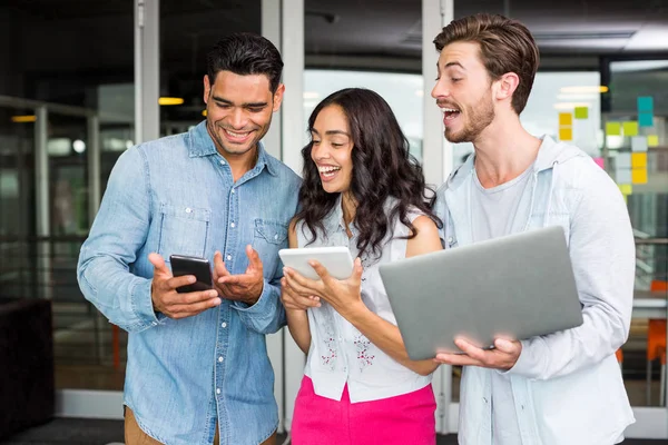 Happy executives using mobile phone, laptop and digital tablet — Stock Photo, Image