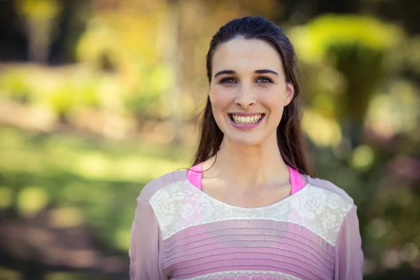 Mujer sonriente de pie en el parque — Foto de Stock