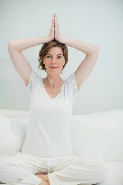 Женщина делает упражнения йоги на кровати — стоковое фото