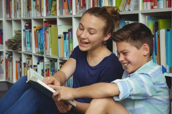 Crianças da escola lendo livros na biblioteca na escola — Fotografia de Stock