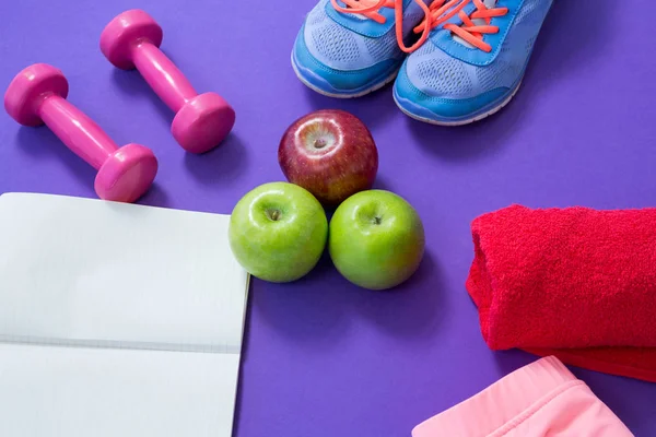 Acessórios de fitness com livro aberto e maçãs — Fotografia de Stock