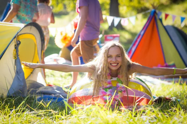 Woman leaning on beach ball at campsite — Stock Photo, Image