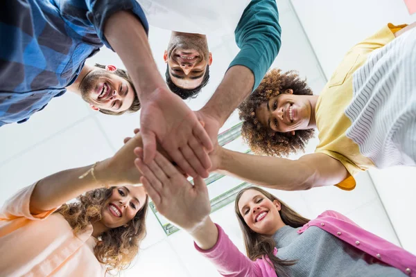 Team lächelnder Führungskräfte bildet Handstapel — Stockfoto