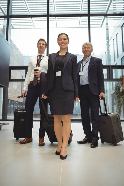 Empresarios de pie junto con el equipaje — Foto de Stock