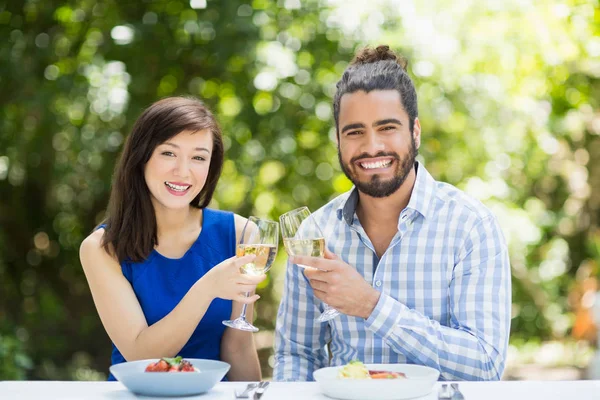 Casal brindar copos de vinho em um restaurante — Fotografia de Stock