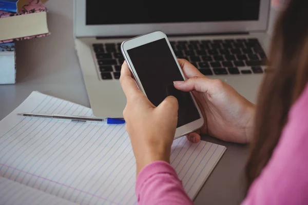 Uczennica w bibliotece przy użyciu telefonu komórkowego — Zdjęcie stockowe