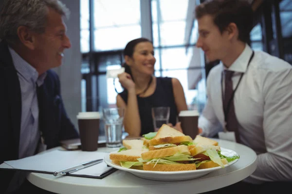 Gente de negocios interactuando mientras desayunan — Foto de Stock