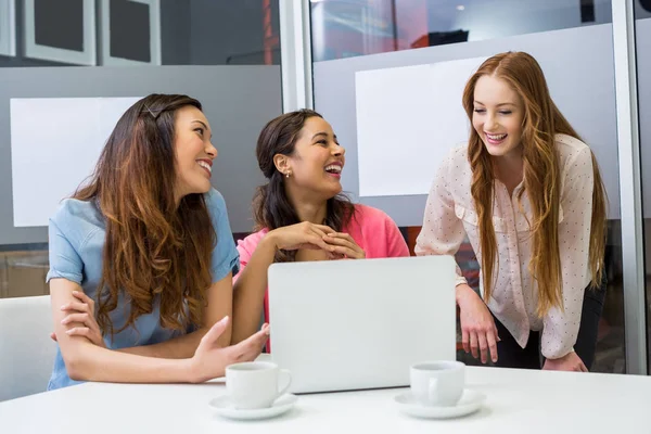 Lachende leidinggevenden bespreken over laptop in vergaderruimte — Stockfoto