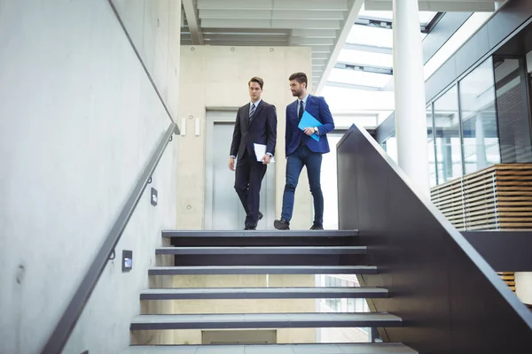 Two businessman walking down the stairs — Stock Photo, Image