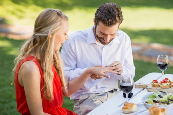 Mann legt Frauen im Restaurant einen Ring an den Finger — Stockfoto