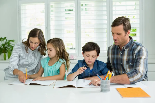 Frères et sœurs recevant de l'aide des parents pour leurs devoirs — Photo