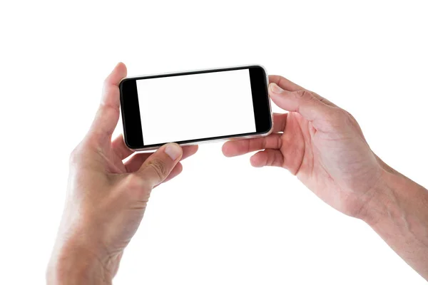 Mãos segurando um telefone celular contra fundo branco — Fotografia de Stock