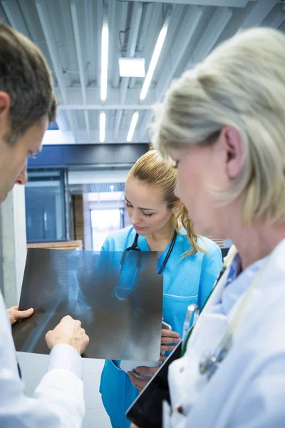 Equipo médico discutiendo sobre informe de rayos X — Foto de Stock