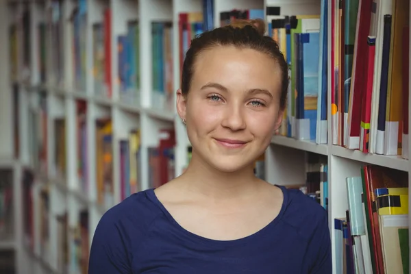Портрет улыбающейся школьницы, улыбающейся в библиотеке — стоковое фото