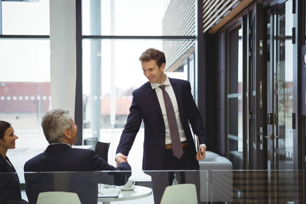 Ondernemers schudden handen in een lobby — Stockfoto