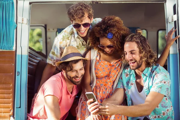 Group of happy friend using mobile phone in campervan — Stock Photo, Image