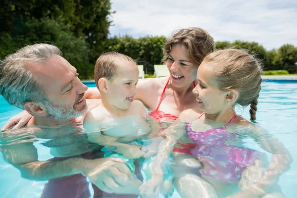 Ebeveynler ve çocuklar eğleniyor şezlong içinde havuz — Stok fotoğraf
