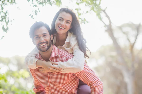 Mannen ger piggyback rida till kvinna — Stockfoto