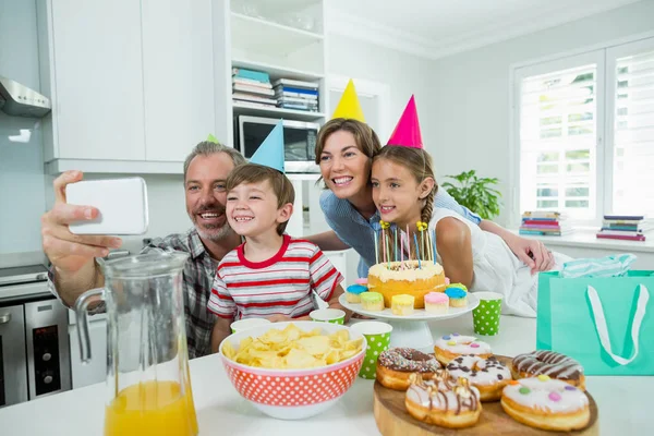 Familia tomando selfie en el teléfono en la cocina —  Fotos de Stock