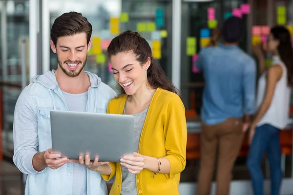 Ejecutivos sonrientes usando laptop — Foto de Stock