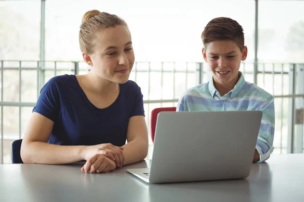 Schoolkinderen met laptop in de bibliotheek — Stockfoto