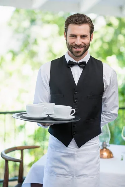 Garçom masculino segurando bandeja com xícaras de café — Fotografia de Stock