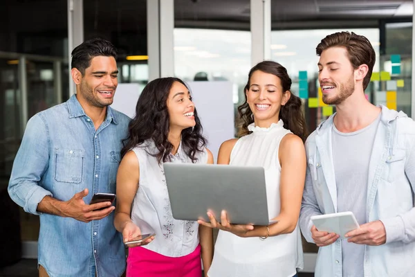 Ejecutivos felices usando portátil, tableta digital y teléfono móvil — Foto de Stock