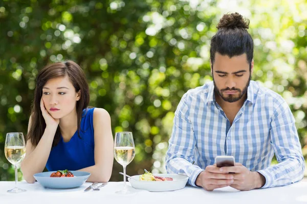Мужчина игнорирует женщину и использует мобильный телефон — стоковое фото