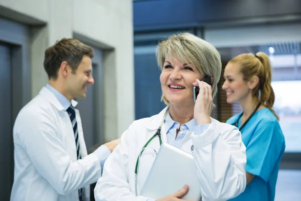 Female doctor talking on mobile phone — Stock Photo, Image