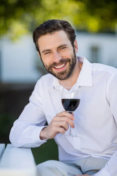 Man holding glass of wine in the park — Stock Photo, Image