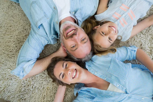 Father with son and daughter lying on carpet — Stock Photo, Image