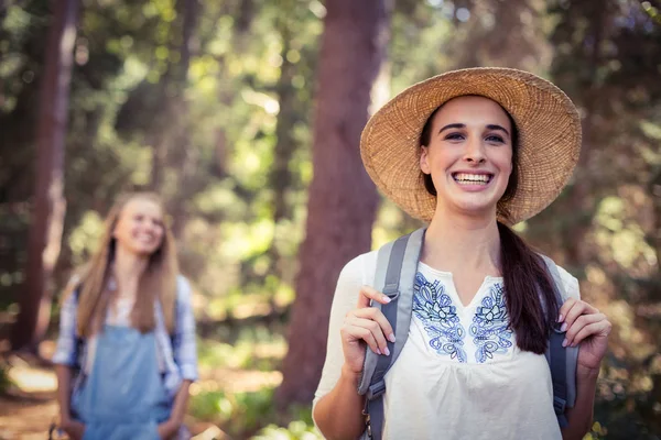 Улыбающаяся женщина в шляпе, стоящая в лесу — стоковое фото