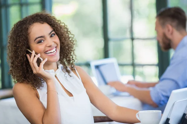 Mooie vrouw praten op mobiele telefoon in een restaurant — Stockfoto