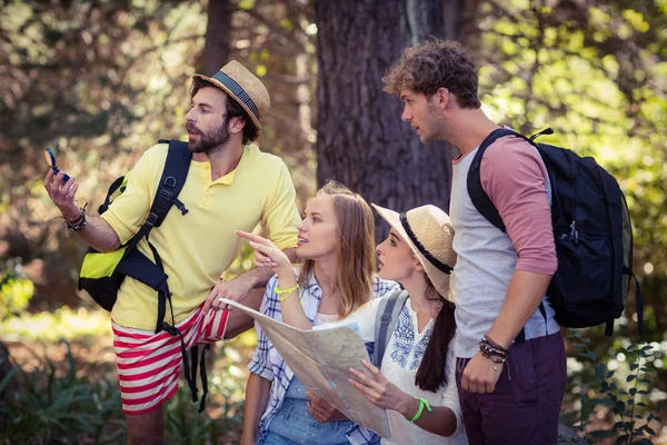 Amigos com um mapa olhando para uma direção — Fotografia de Stock