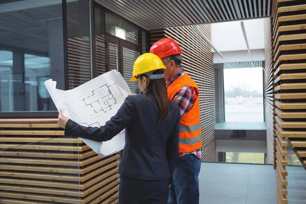 Businesswoman discussing over blueprint with architect — Stock Photo, Image