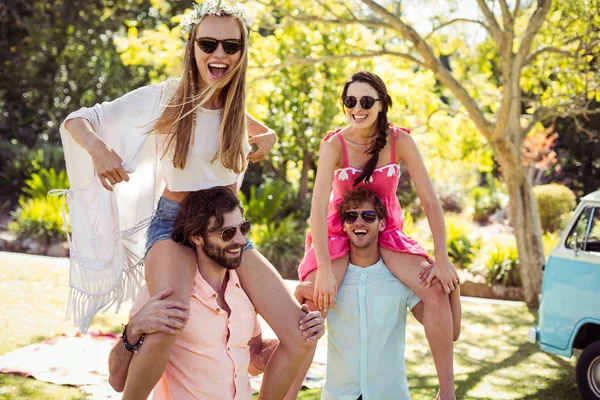 Hombres cargando mujeres sobre sus hombros en el parque — Foto de Stock