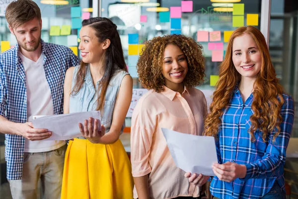 Portrait of smiling executives discussing over documents — Stock Photo, Image