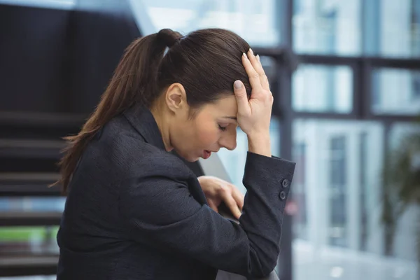 Deprimerad affärskvinna med handen på huvudet — Stockfoto