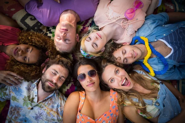 Group of friends lying in a circle at campsite — Stock Photo, Image