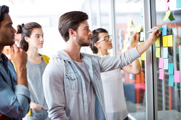 Executives discussing over sticky notes during meeting — Stock Photo, Image