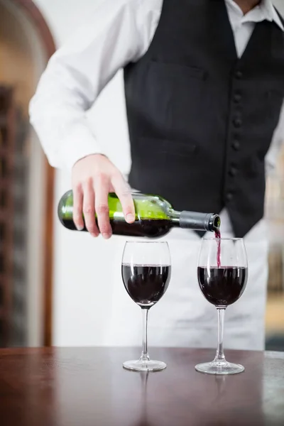 Mężczyzna kelner nalewanie wina w kieliszki do wina — Zdjęcie stockowe