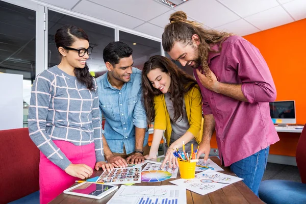 Grafica sorridente che lavora sopra le foto alla scrivania — Foto Stock