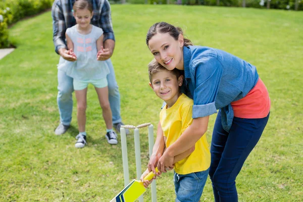 Familj spelar cricket i park — Stockfoto