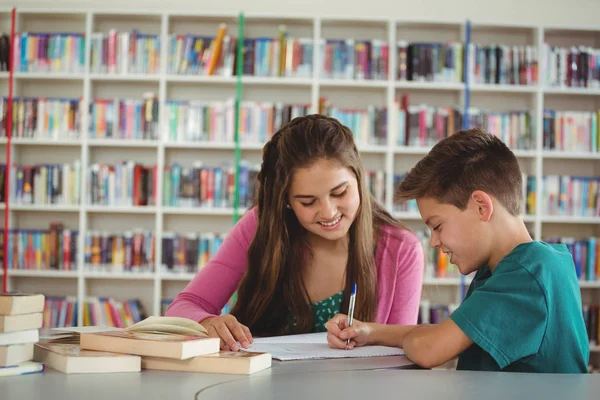 Schulkinder machen Hausaufgaben in der Schulbibliothek — Stockfoto