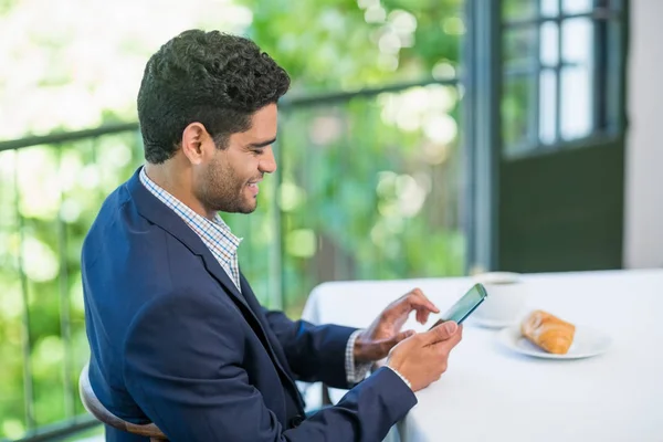 Hombre de negocios sonriente usando teléfono móvil — Foto de Stock