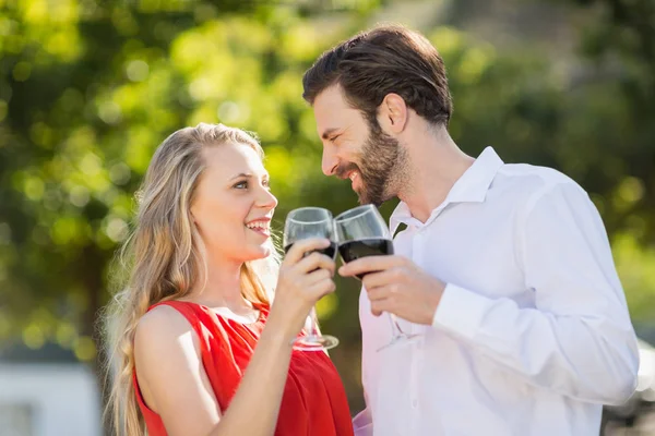 Glückliches Paar beim Anstoßen auf Weingläser — Stockfoto