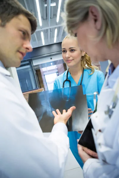 Equipo médico discutiendo sobre informe de rayos X — Foto de Stock