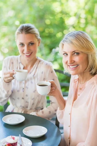 Amigos sonrientes disfrutando del café juntos — Foto de Stock