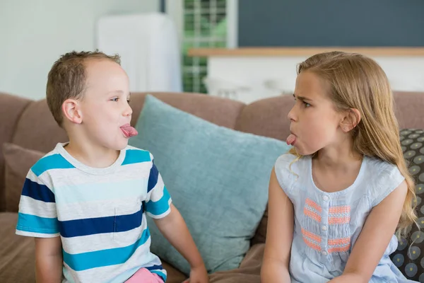 Hermana y hermano sobresalen lenguas el uno al otro —  Fotos de Stock