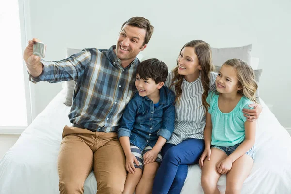 Man tar selfie med familj i sovrum — Stockfoto